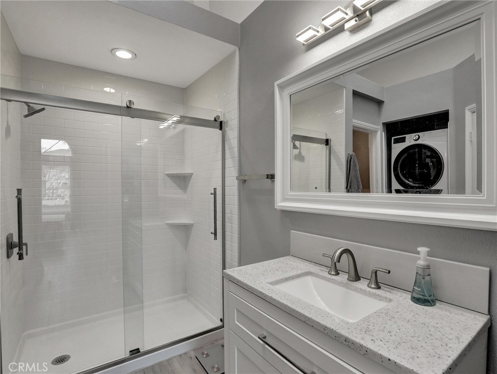 25081 Leucadia Street, Unit F Laguna Niguel, CA 92677 - Photo 16 of 30 a bathroom with a sink a shower a mirror and shower