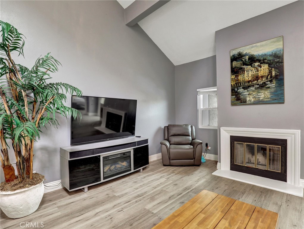 25081 Leucadia Street, Unit F Laguna Niguel, CA 92677 - Photo 5 of 30 a living room with furniture a flat screen tv and a fireplace