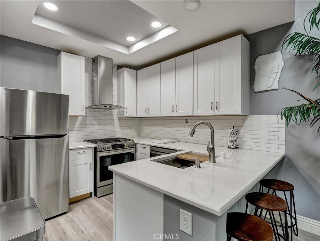 25081 Leucadia Street, Unit F Laguna Niguel, CA 92677 - Photo 6 of 30 a kitchen with stainless steel appliances a stove a sink a refrigerator and cabinets