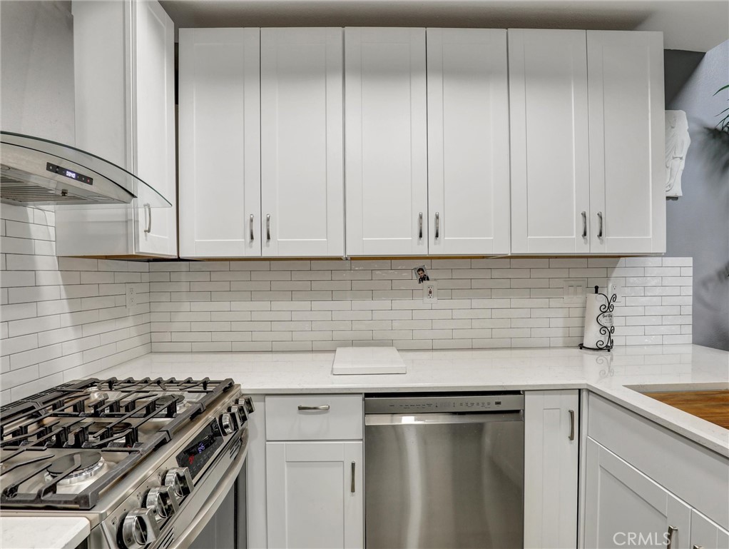 25081 Leucadia Street, Unit F Laguna Niguel, CA 92677 - Photo 9 of 30 a kitchen with granite countertop white cabinets and stainless steel appliances