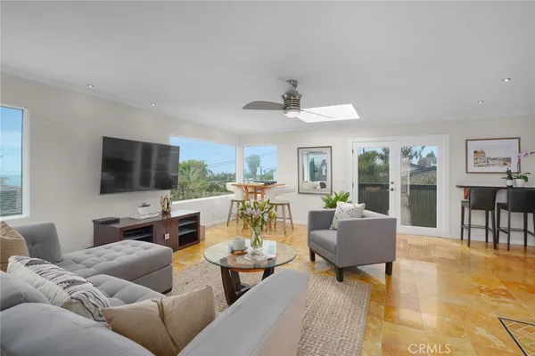 a living room with furniture kitchen view and a flat screen tv