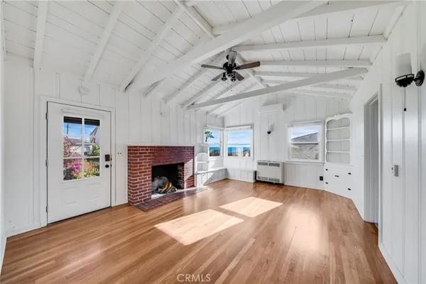 a view of a livingroom with a fireplace a chandelier and wooden floor