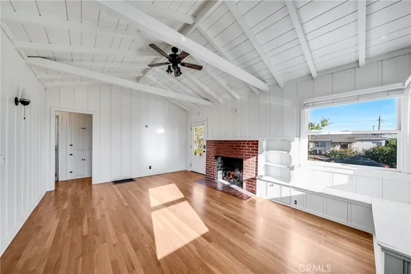 a view of empty room with wooden floor and fireplace