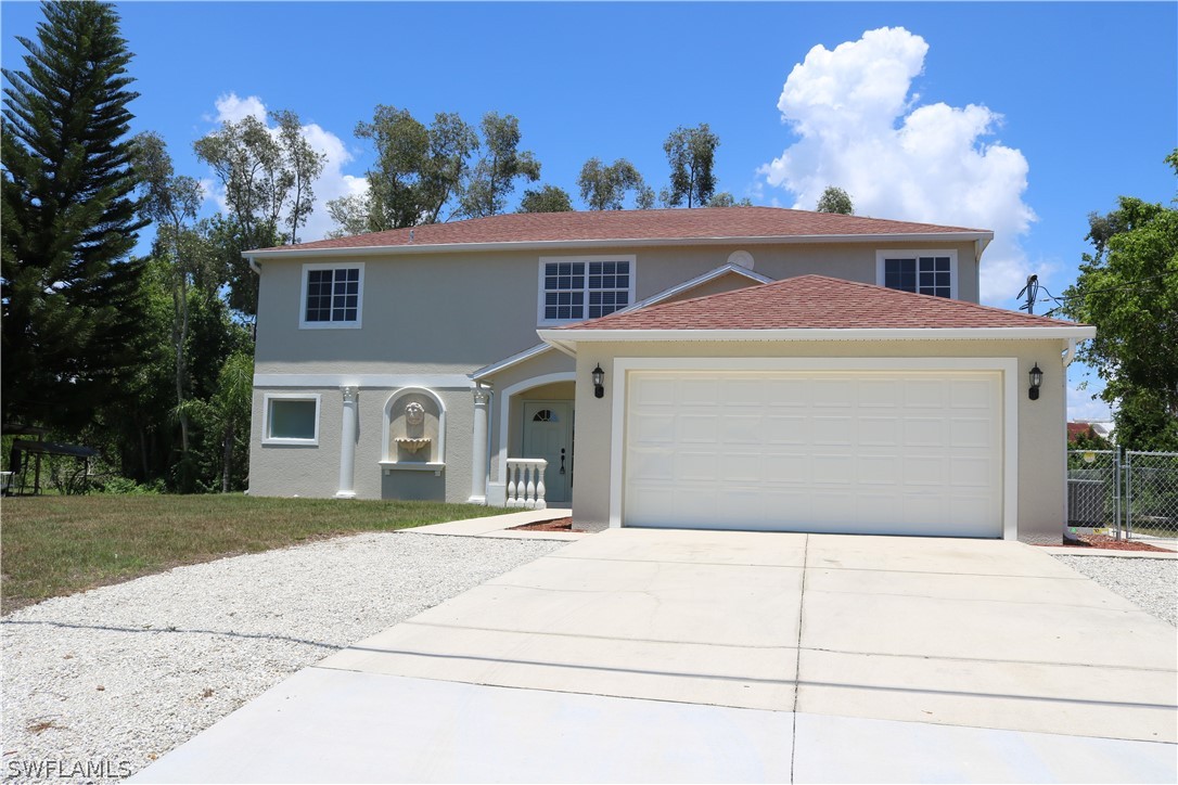 18425 Iris Road Fort Myers, FL 33967 - Photo 1 of 27 a front view of a house with a yard and a garage