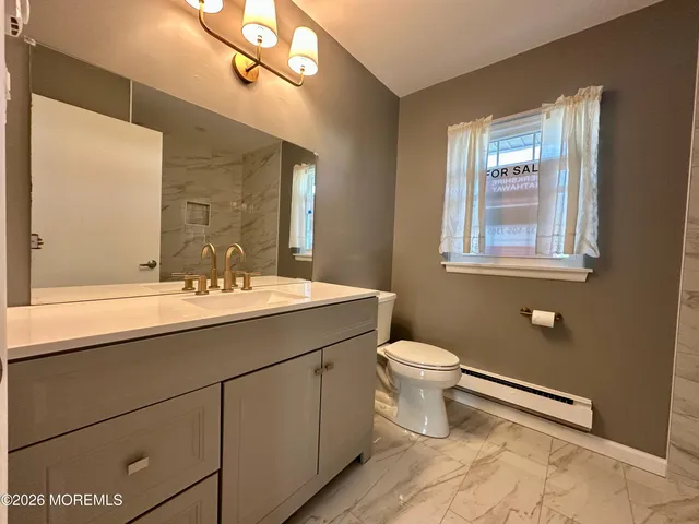 a bathroom with a sink toilet and mirror