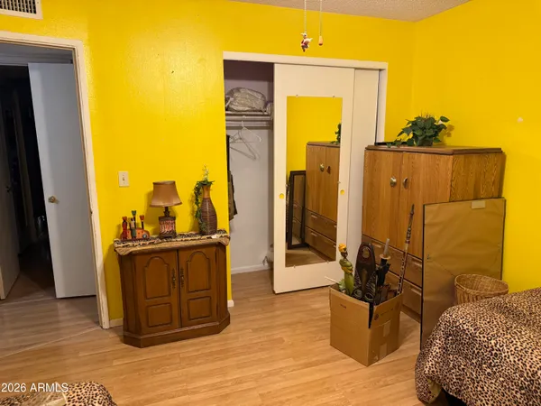 a view of a bedroom with wooden floor and furniture