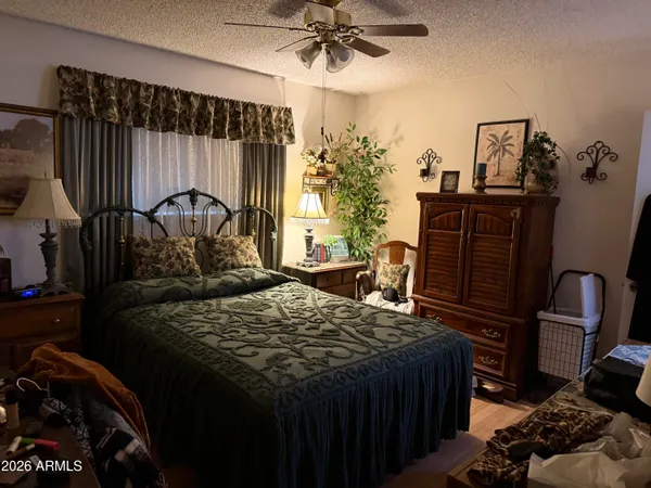 a bedroom with a bed a dresser and potted plants