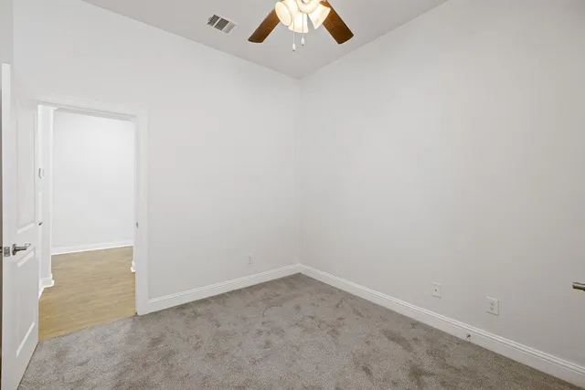 an empty room with a ceiling fan