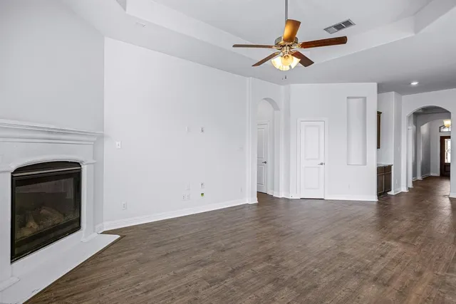 an empty room with windows and fireplace