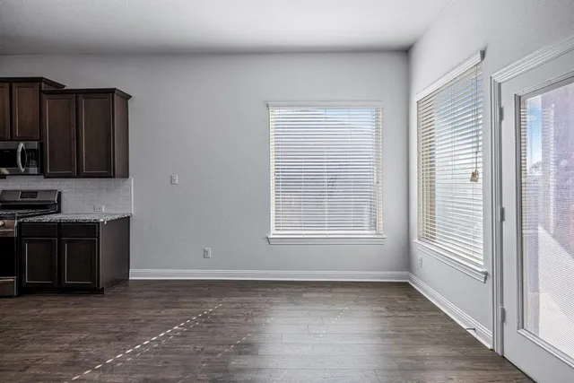 a view of an empty room with chandelier fan and fire place