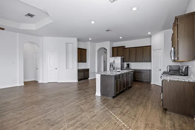 a view of a kitchen with wooden floor and a window