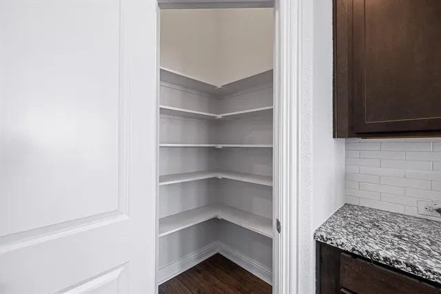 a kitchen with granite countertop wooden cabinets a refrigerator and a sink