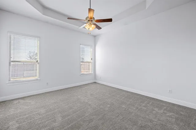an empty room with closet and a ceiling fan