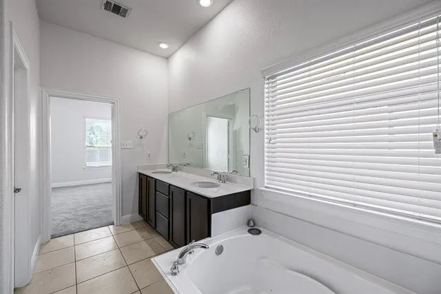 a bathroom with a tub shower and sink