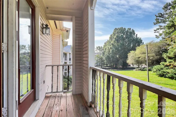a view of balcony with wooden floor and fence