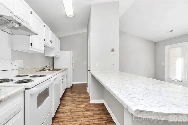 a kitchen with stainless steel appliances granite countertop a white stove top oven sink and cabinets