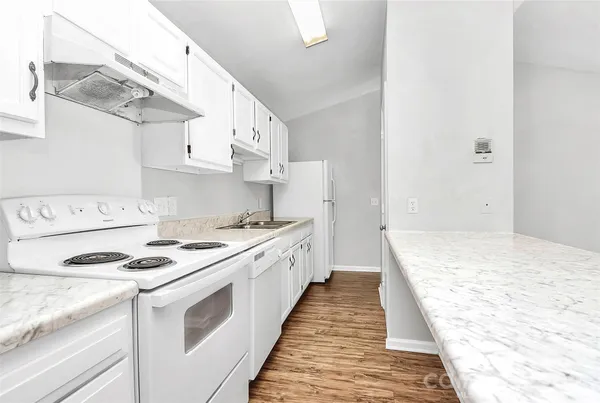 a kitchen with stainless steel appliances a stove a sink and white cabinets