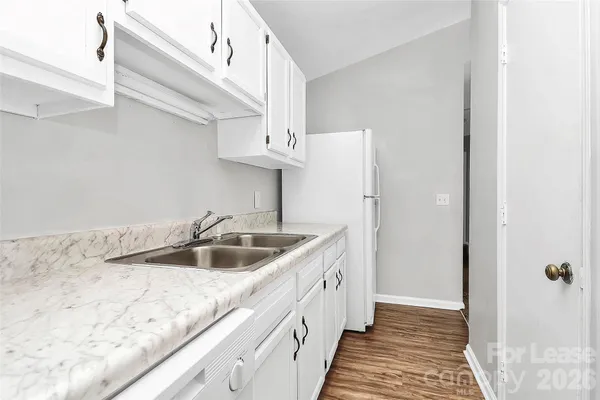 a kitchen with stainless steel appliances granite countertop a sink and a refrigerator