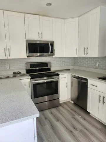 a kitchen with cabinets appliances and a sink