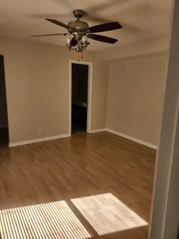 a view of a hallway with wooden floor and chandelier