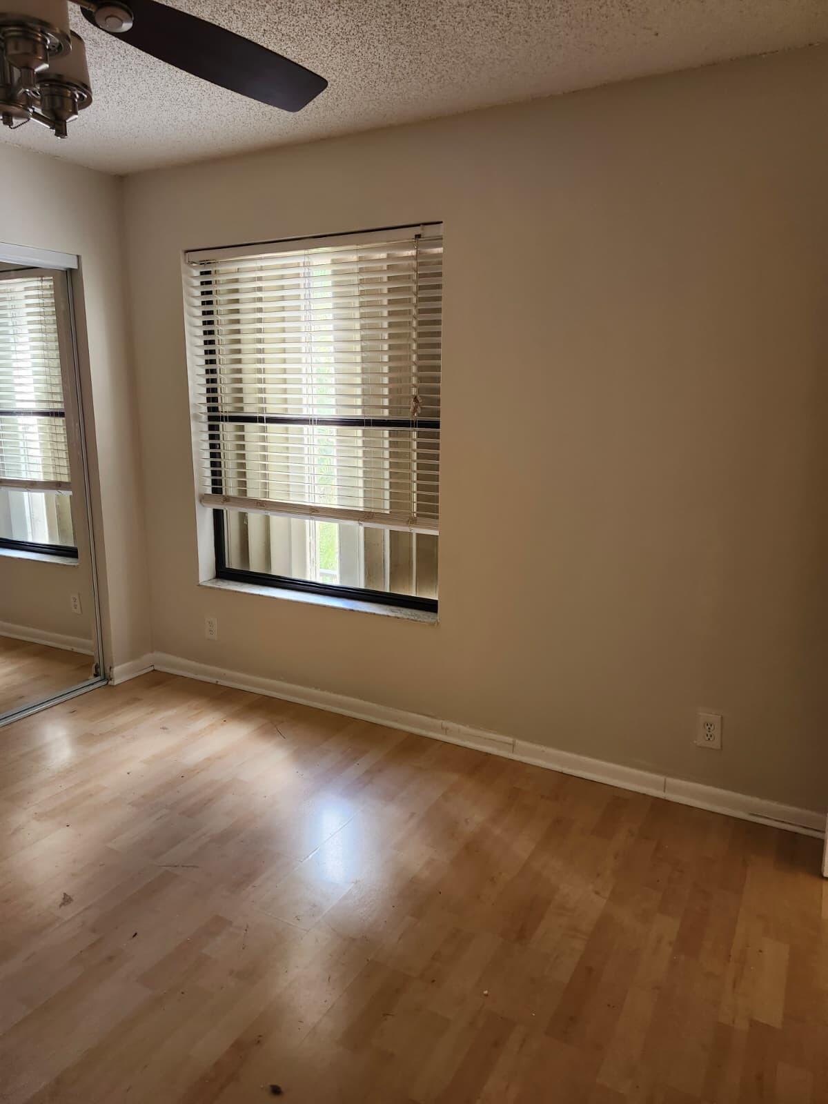 7519 Courtyard Run East Boca Raton, FL 33433 - Photo 17 of 29 an empty room with wooden floor and windows