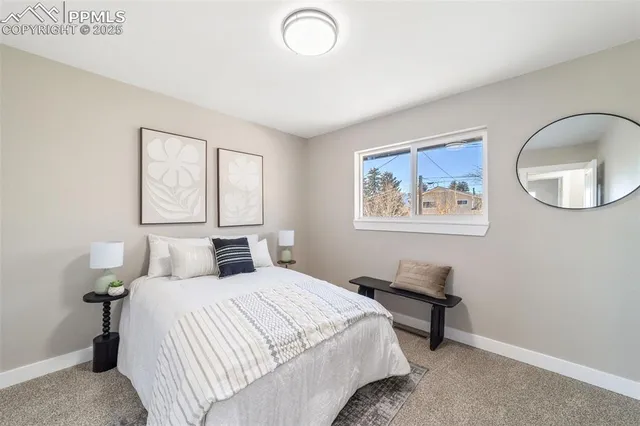 a bedroom with a bed and a painting on the wall