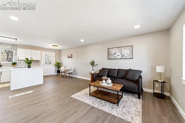 a living room with furniture and wooden floor