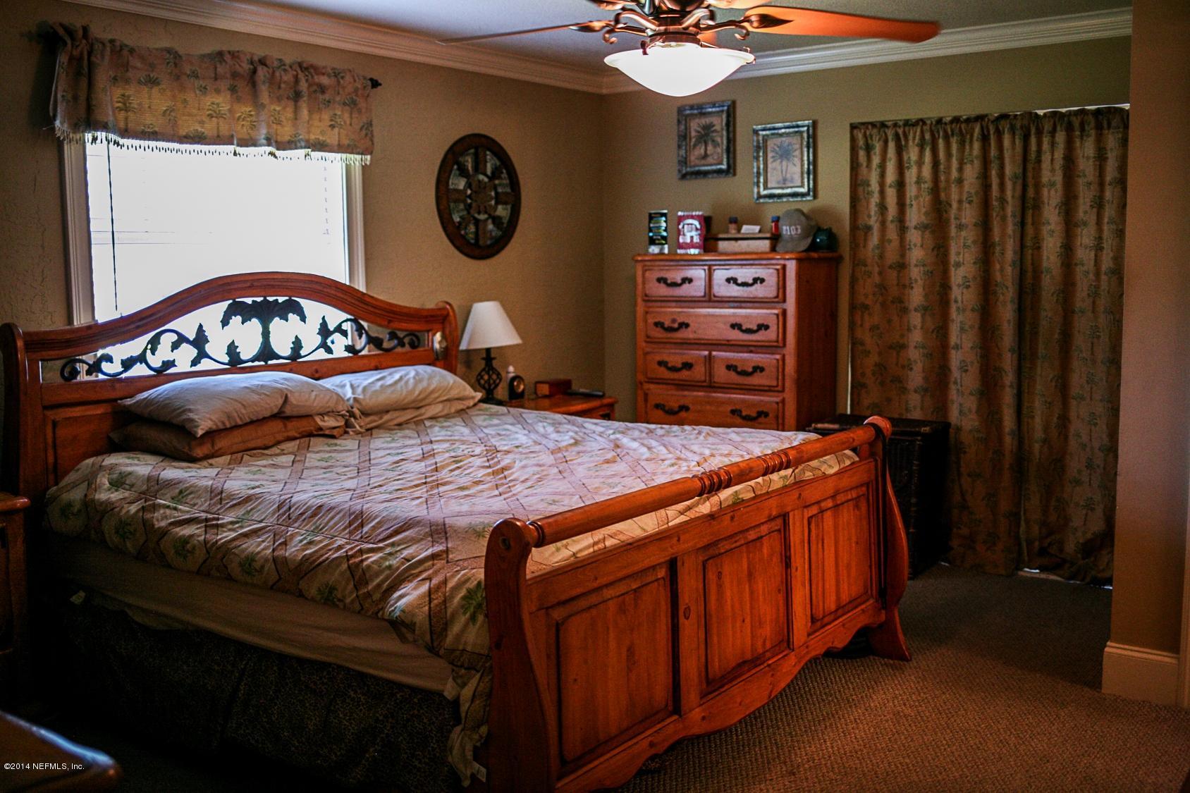 3967 Eunice Road Jacksonville, FL 32250 - Photo 15 of 28 a bed sitting in a bedroom next to a window