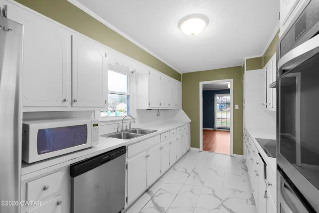 a kitchen with stainless steel appliances a sink stove and cabinets