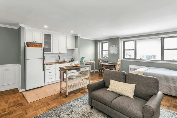 a living room with furniture and a refrigerator