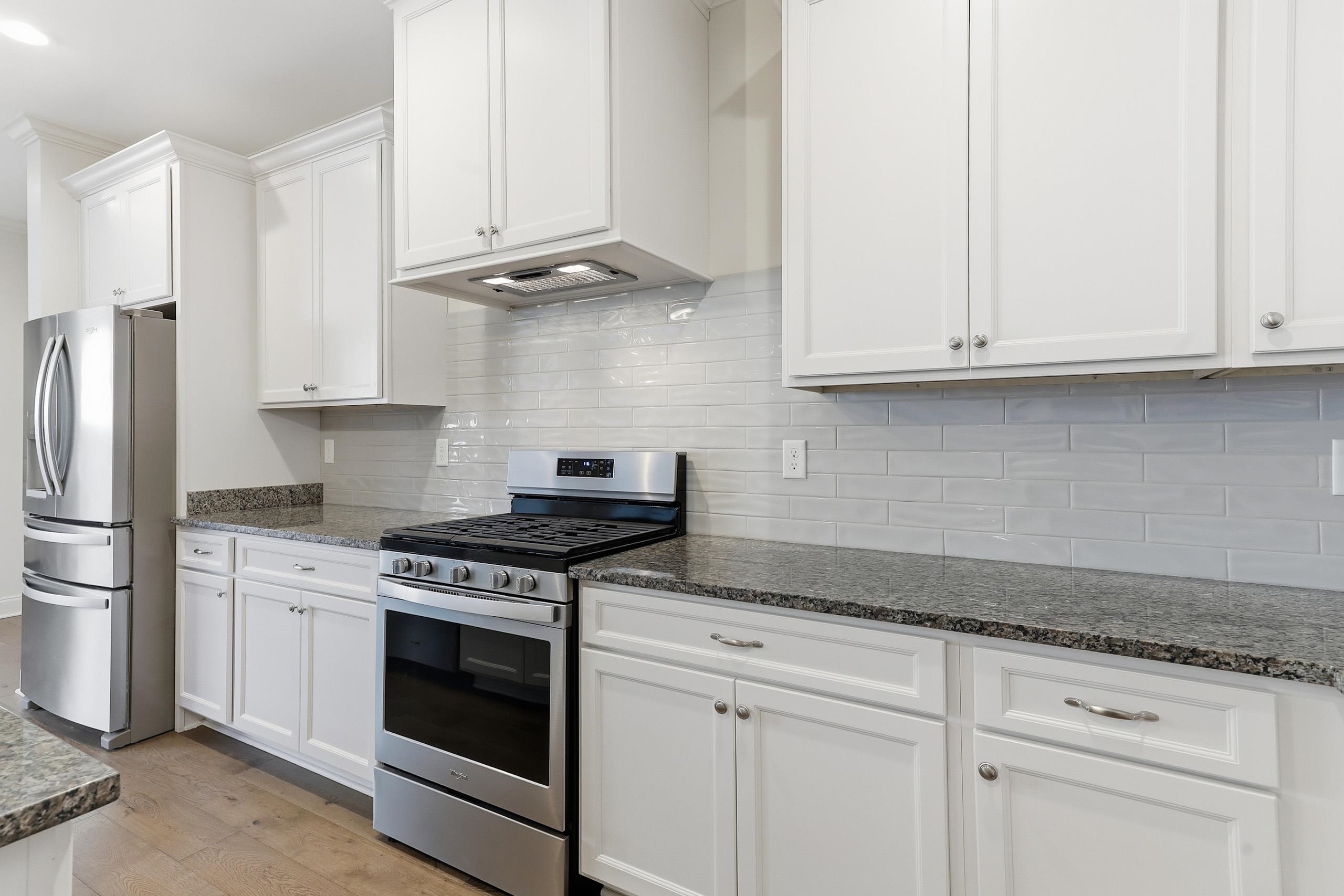 897 Ufton Alley Collierville, TN 38017 - Photo 13 of 32 a kitchen with granite countertop white cabinets and stainless steel appliances