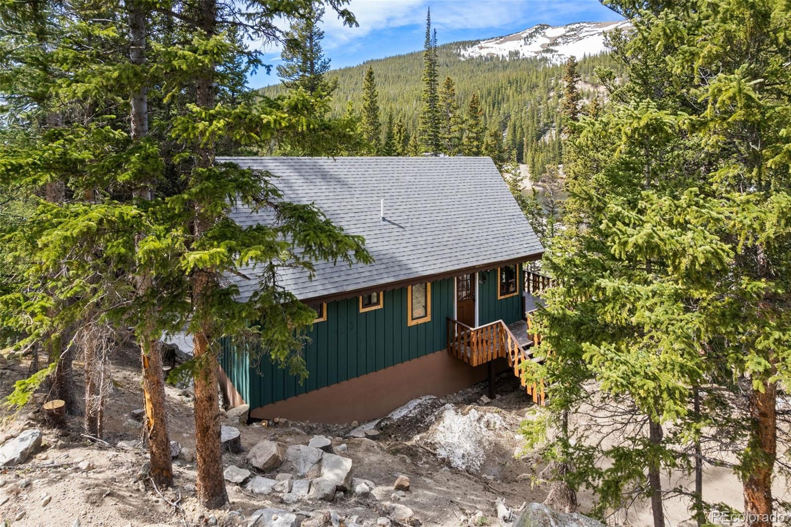 827 Mine Road Idaho Springs, CO 80452 - Photo 23 of 30 a backyard of a house with table and chairs under an umbrella