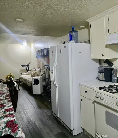 a kitchen with a refrigerator and white cabinets