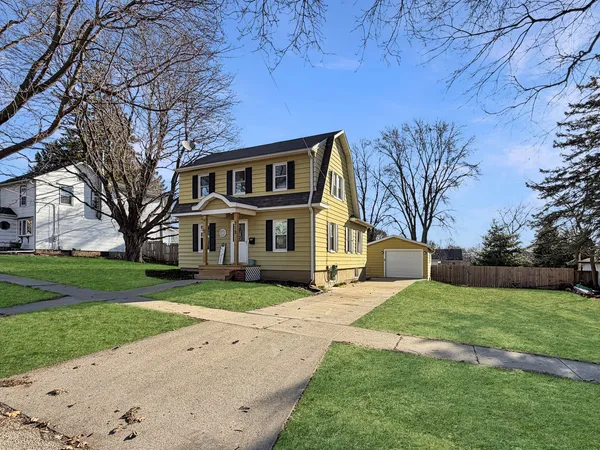 a front view of a house with a yard and trees