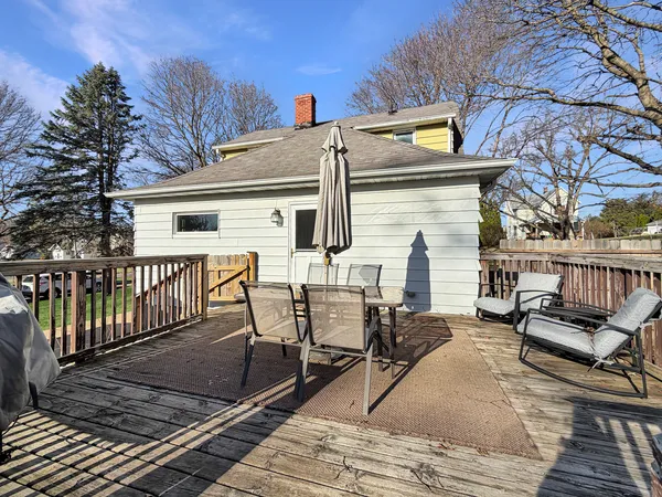 a view of a patio with table and chairs with wooden fence and floor