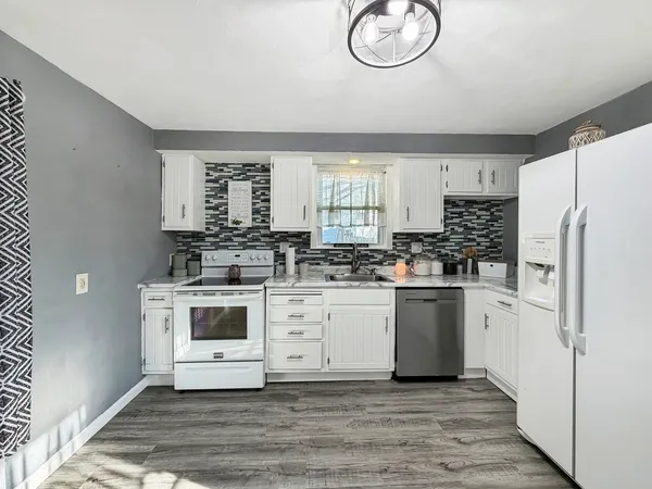 a kitchen with stainless steel appliances granite countertop a stove a sink and a refrigerator
