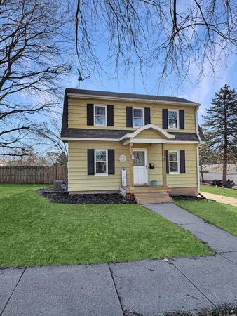a front view of a house with a garden and yard