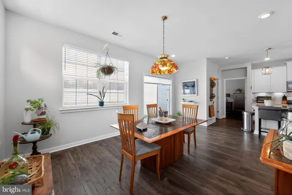 a view of a dining room and livingroom with furniture wooden floor a chandelier