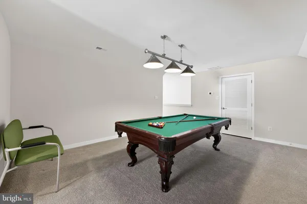 a room with pool table and wooden floor