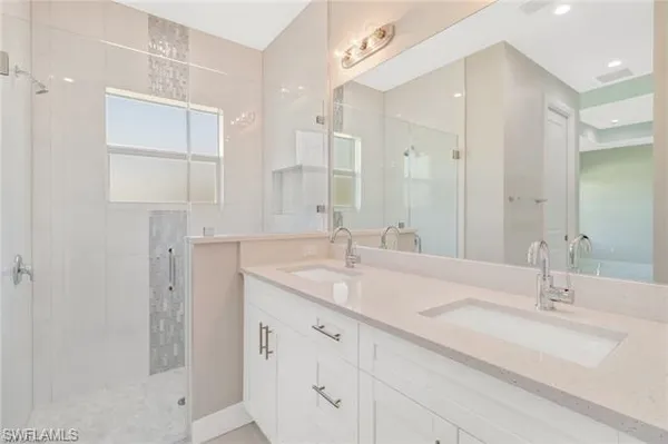 a bathroom with double sink and a mirror
