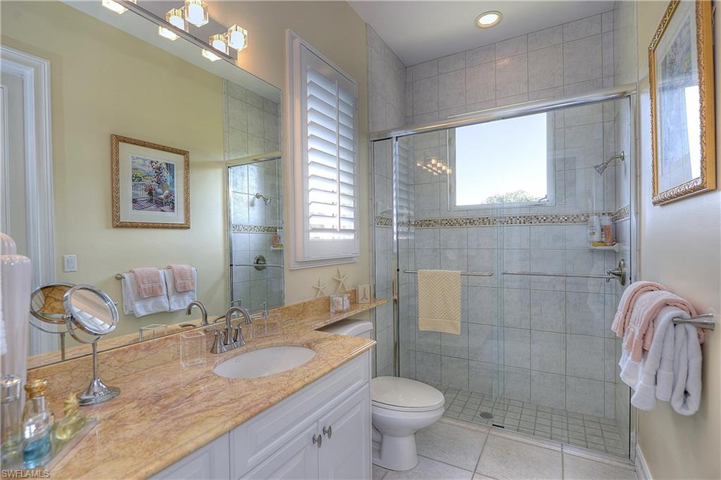 3274 Sedge Place Naples, FL 34105 - Photo 16 of 24 a bathroom with a granite countertop sink a toilet a mirror and shower