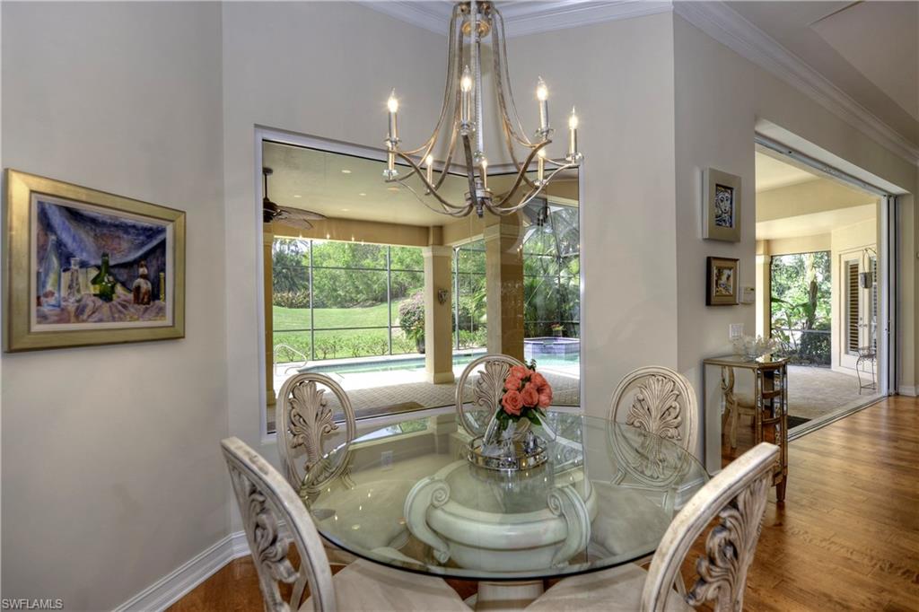 3274 Sedge Place Naples, FL 34105 - Photo 9 of 24 a dining room with furniture a chandelier and wooden floor