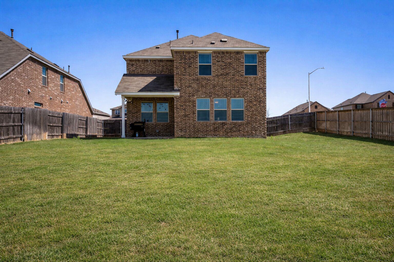 974 Pepperbark Loop Buda, TX 78610 - Photo 37 of 40 Back of property featuring an oversized backyard, covered patio and four-sided masonry.