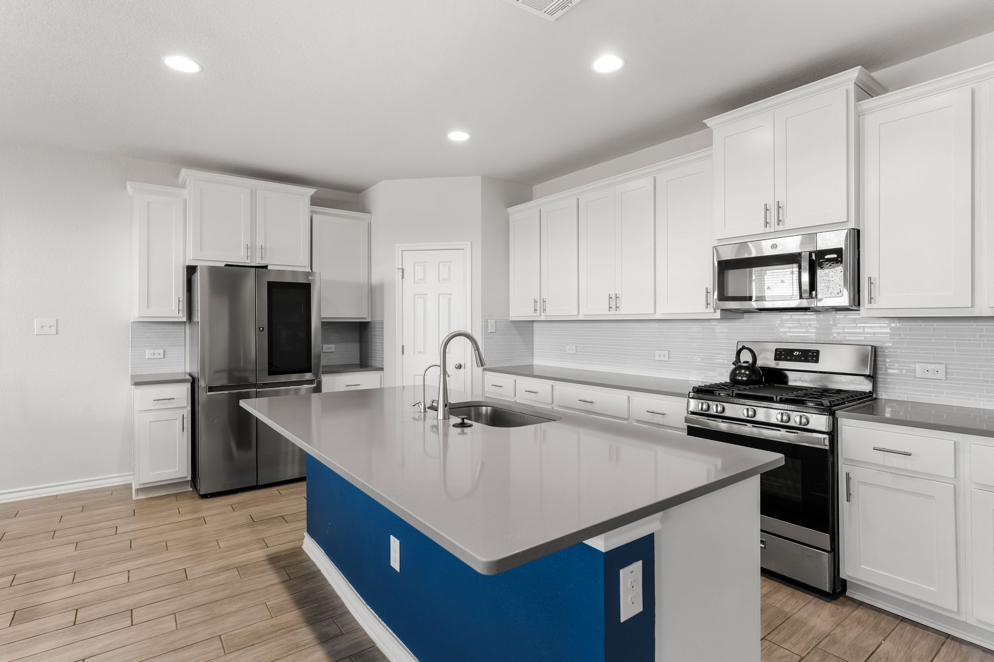 974 Pepperbark Loop Buda, TX 78610 - Photo 8 of 40 Second view of kitchen with white cabinets and stainless steel hardware.