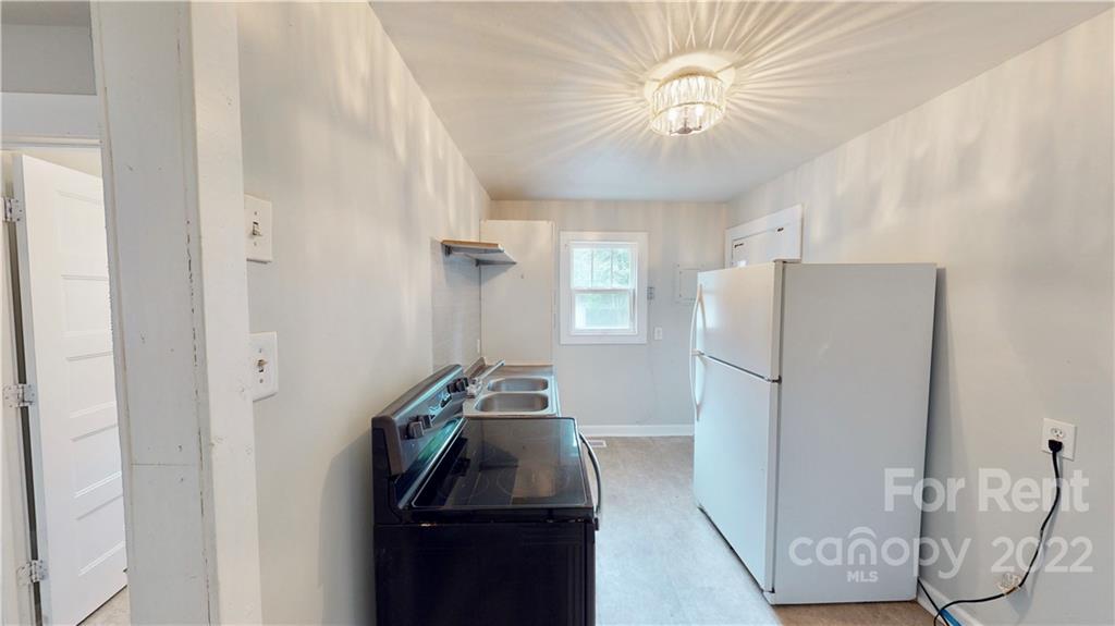 825 Rodey Avenue, Unit 1 Charlotte, NC 28206 - Photo 12 of 15 a kitchen with a refrigerator and a chandelier