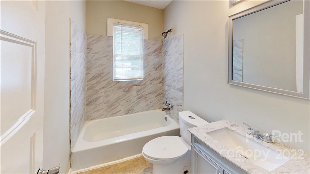 825 Rodey Avenue, Unit 1 Charlotte, NC 28206 - Photo 7 of 15 a bathroom with a granite countertop toilet sink and bathtub