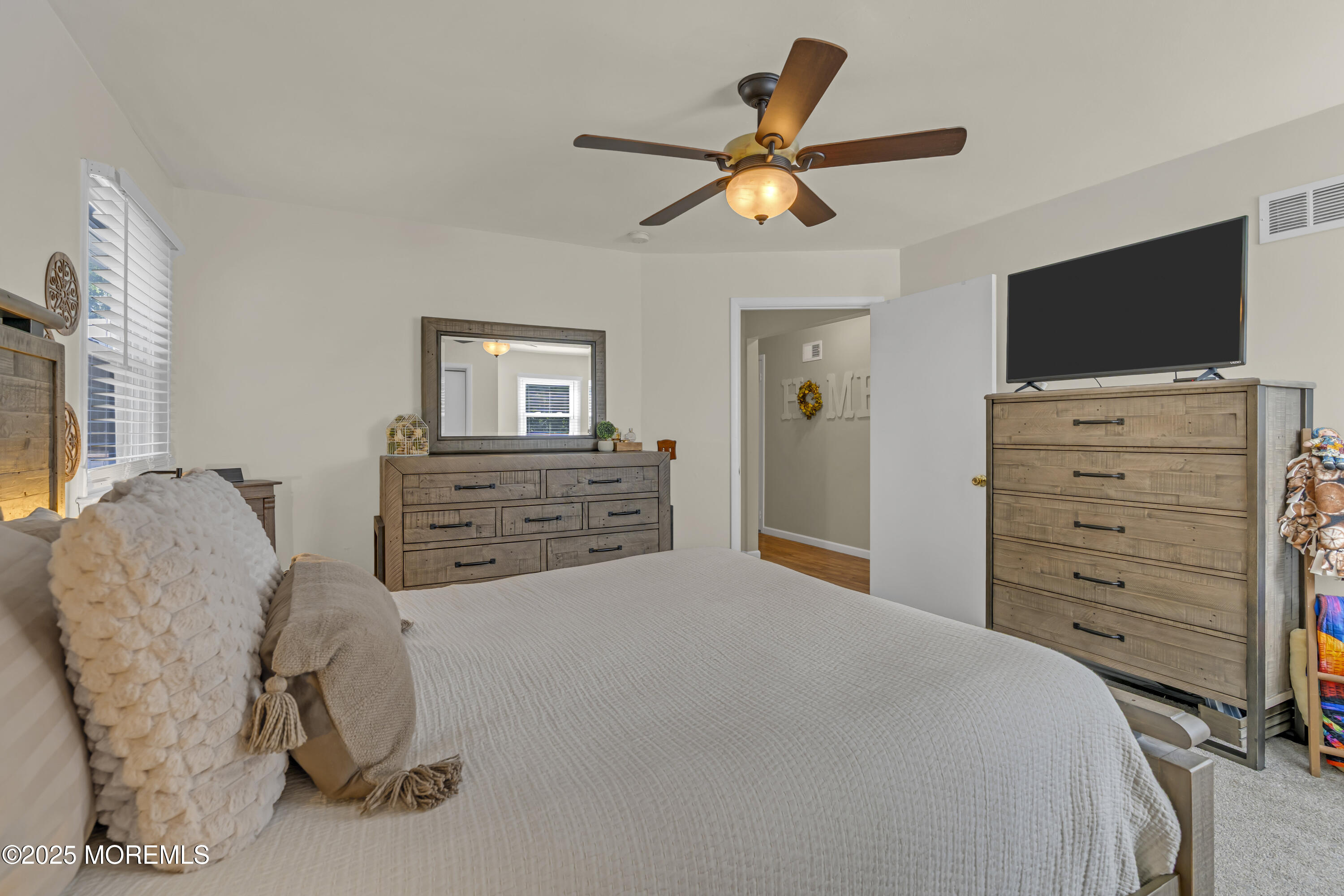 910 Woodlane Road Jackson, NJ 08527 - Photo 22 of 36 a bedroom with a bed and a flat screen tv