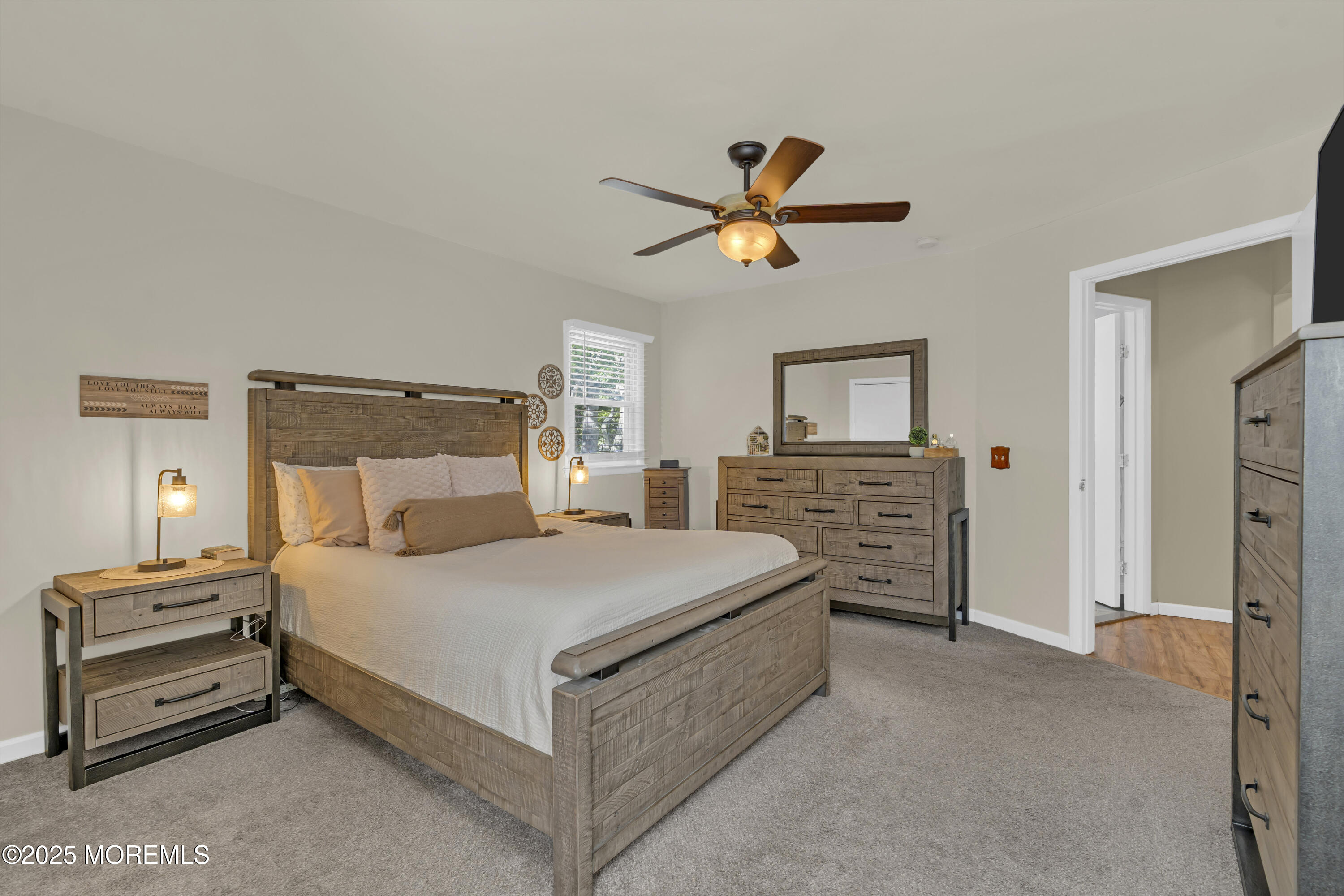 910 Woodlane Road Jackson, NJ 08527 - Photo 23 of 36 a bedroom with a bed a dresser and a chandelier