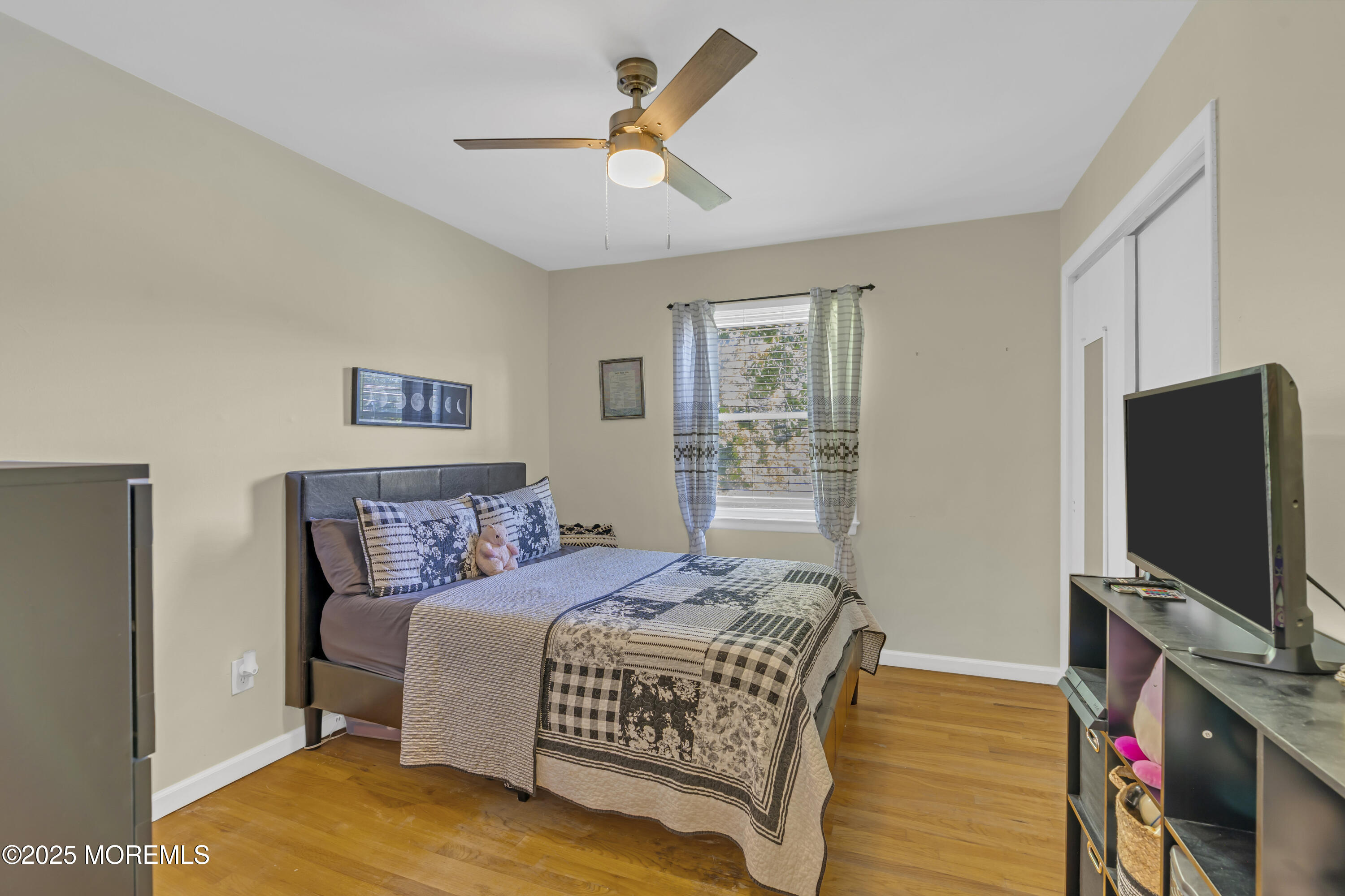 910 Woodlane Road Jackson, NJ 08527 - Photo 24 of 36 a bedroom with a bed and a flat screen tv