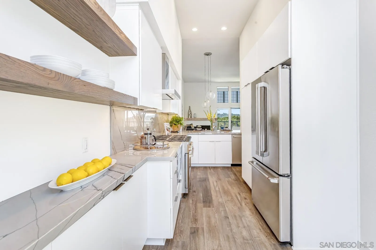 1031 Reliance Way Del Mar, CA 92014 - Photo 6 of 33 a kitchen with white cabinets and stainless steel appliances